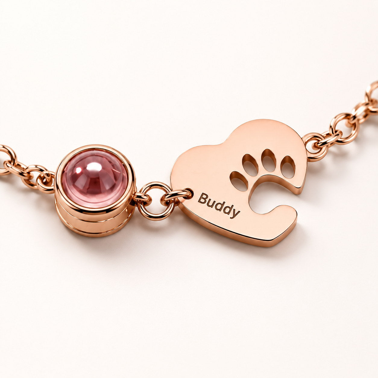 Rose gold Paw Heart Birthstone Bracelet close-up with pink birthstone and Buddy charm